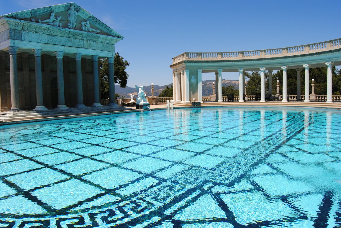 Piscina esterna con mosaici e architettura classica.
